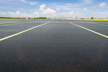 Newly paved asphalt parking lot with yellow line striping in Oklahoma City