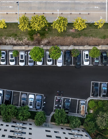 Aerial view of asphalt parking lot for apartment complex and commercial properties.