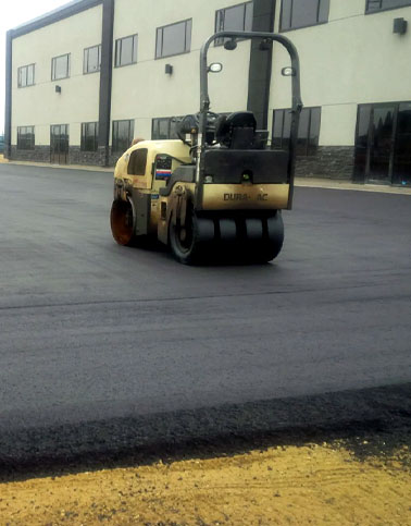 Asphalt paving equipment on commercial property and parking lot construction.