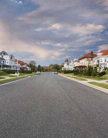 HOA community street with asphalt paving and residential properties