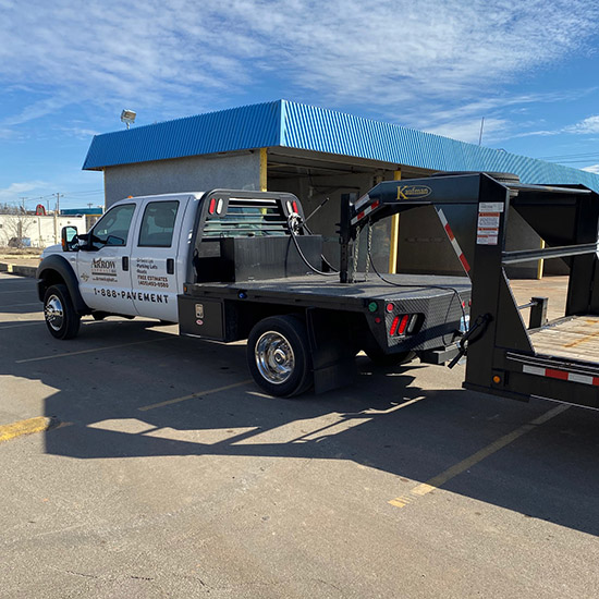 Arrow Asphalt LLC truck and trailer with pavement equipment in Edmond, OK.