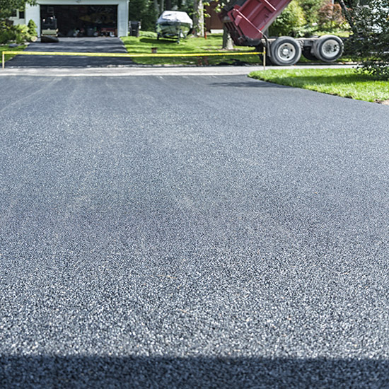 Newly paved asphalt driveway and equipment for residential paving Oklahoma.