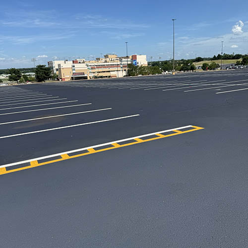 Newly paved asphalt parking lot in Oklahoma City with white and yellow parking lines.