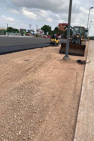 Asphalt paving installation with bulldozer and new asphalt surface in Oklahoma City.