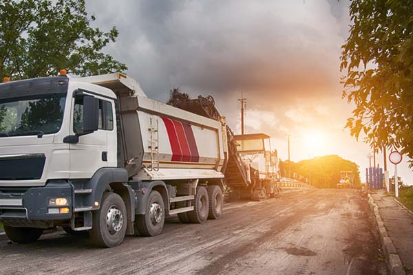 Asphalt milling machine and dump truck for asphalt resurfacing services in Oklahoma.