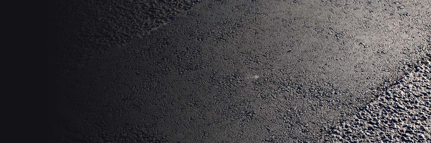 Close-up of freshly patched asphalt surface and repair work