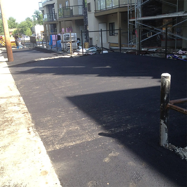 Newly paved asphalt parking lot in Moore, OK, showcasing commercial paving services.